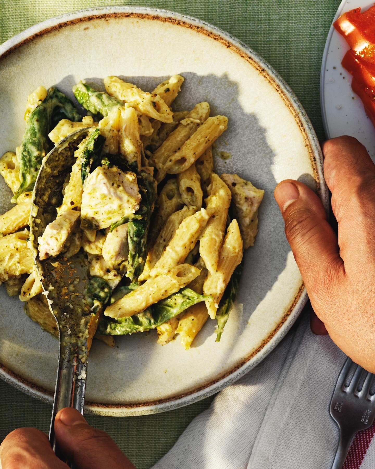 Penne with chicken, pesto and spinach on a plate